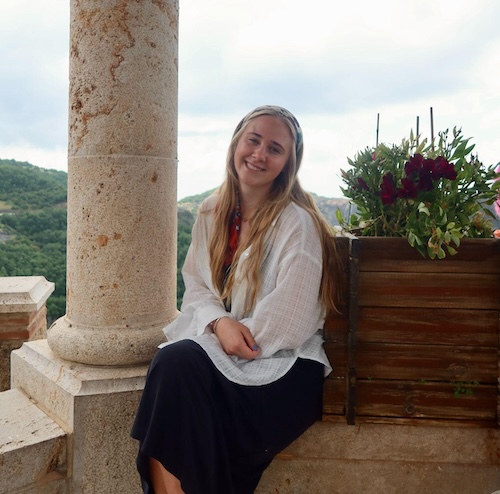 Madeleine Uhlhorn-Thornton in Greece next to a stone column